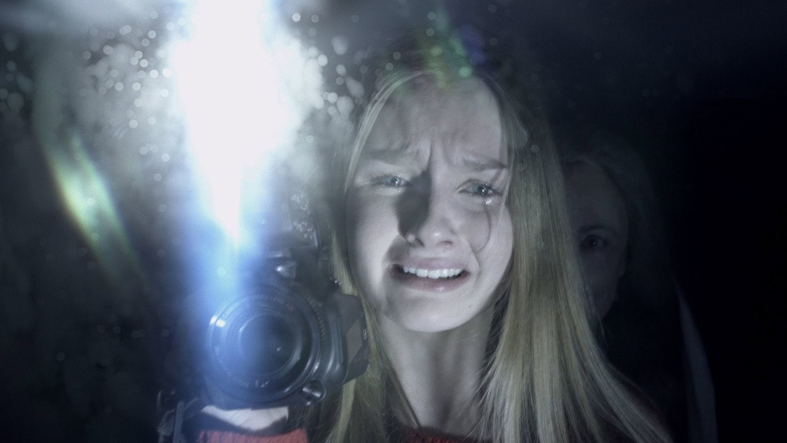 Becca (Olivia DeJonge) se filme dans le miroir dans The Visit