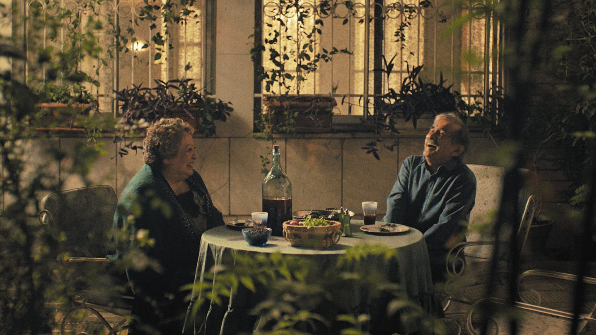 Mahin (Lily Farhadpour) et Faramarz (Esmail Mehrabi) boivent dans la cour dans Mon gâteau préféré